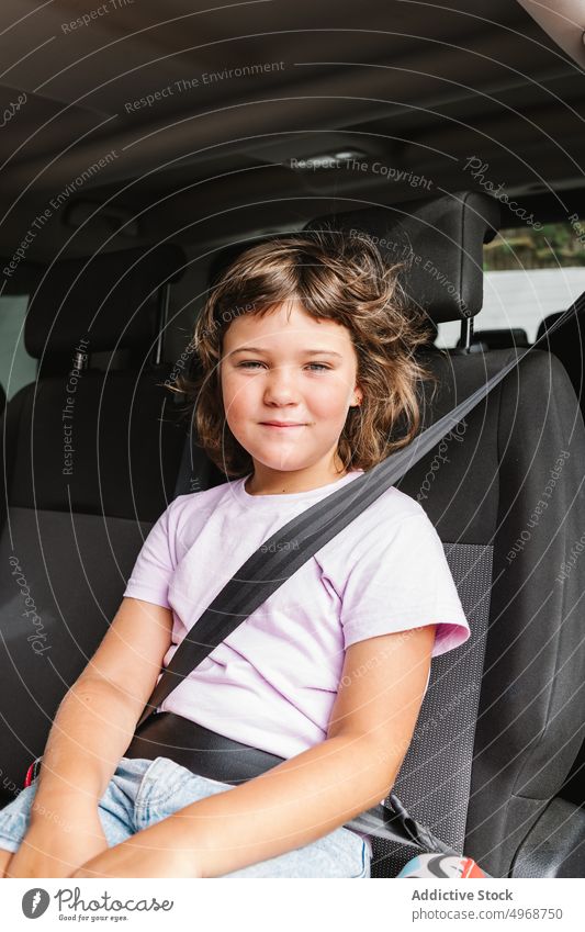 Cheerful girl sitting in car smile backseat road trip happy weekend travel female passenger casual kid journey positive transport auto vehicle ride child