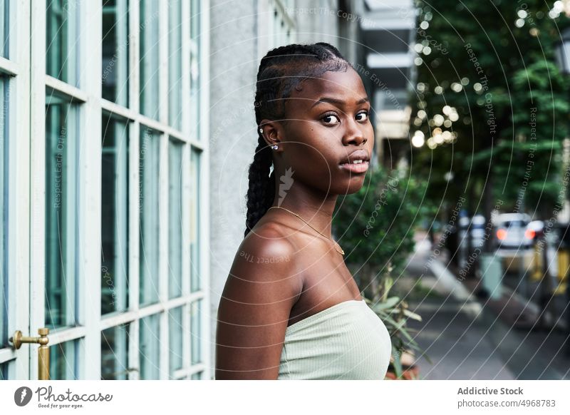 Gorgeous black woman on sidewalk street cool portrait modern mill city personality serious trendy self assured appearance long hair hairstyle african american