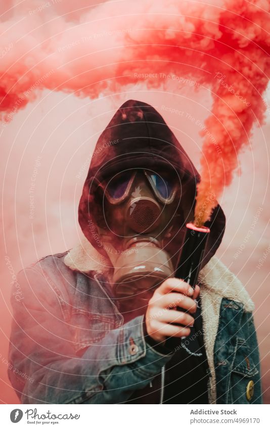 Person holding smoke bomb on street person gas cloud smog steam pink colorful signal rebellion respirator gas mask grenade fume fog toxic chemical flow