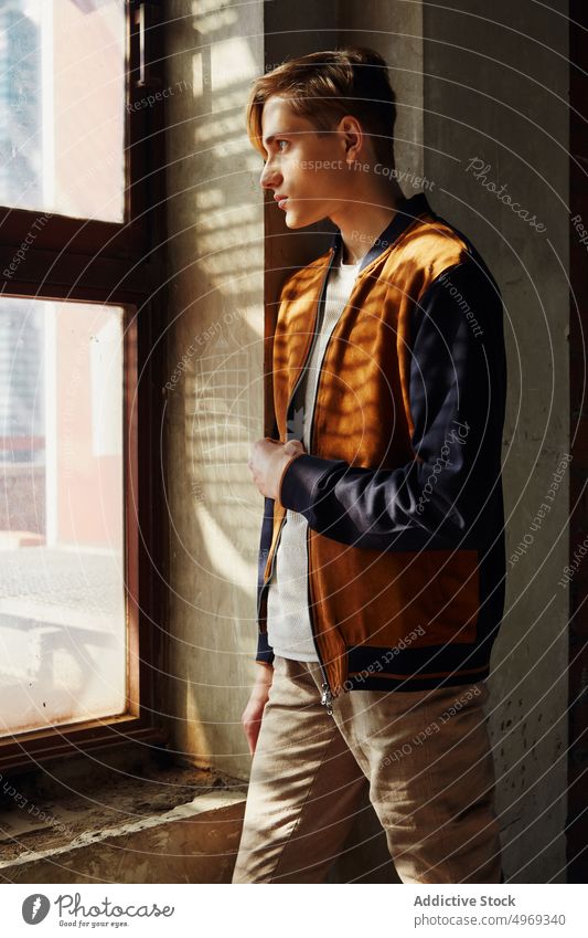 Young male standing near windows man posing model handsome relaxed urban trendy stylish summer young guy attractive confidence vogue serious glamour elegance