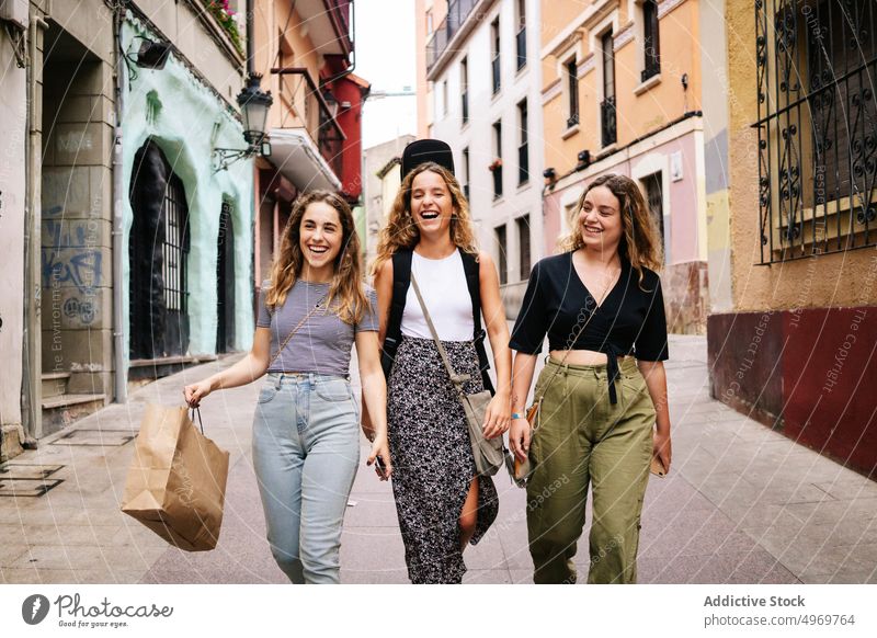 Girl fiends hugging and walking on street women talking meeting friendship bonding group cheerful casual smiling together happy connection communication
