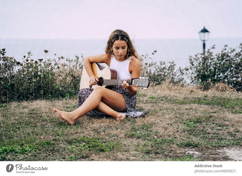 Woman playing guitar in field with dry vegetation music woman romantic young instrument cheerful female musical fun vacation fashion holiday casual summer