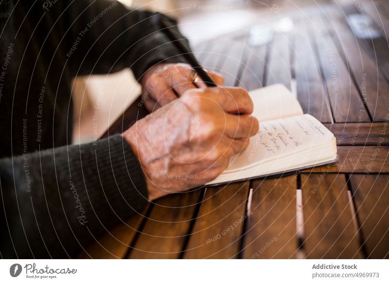 elderly man writing in his notebook lifestyle smart expression construction male business grey home person indoors document adult years write owner accountant