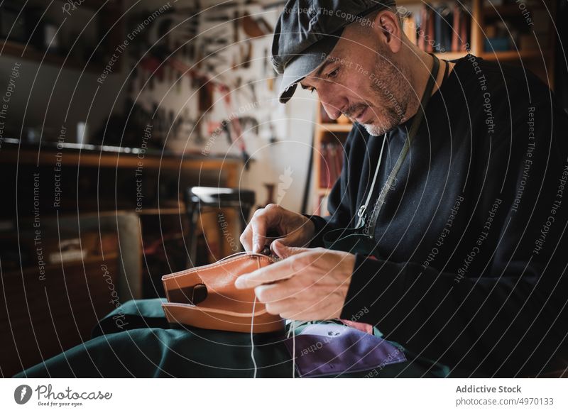 Man sewing textile in atelier tailor needle workshop man leather dickey workplace fashion clothing studio dressmaker design hat craft fabric industry handicraft