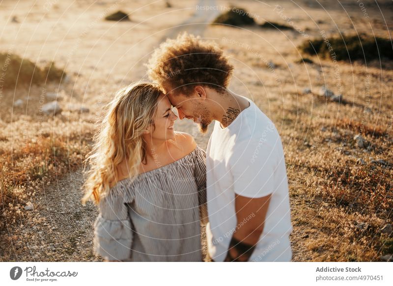 Cheerful adult couple embracing against highland during sunset embrace love sensual happy hill hipster romantic relationship romance affection girlfriend hug
