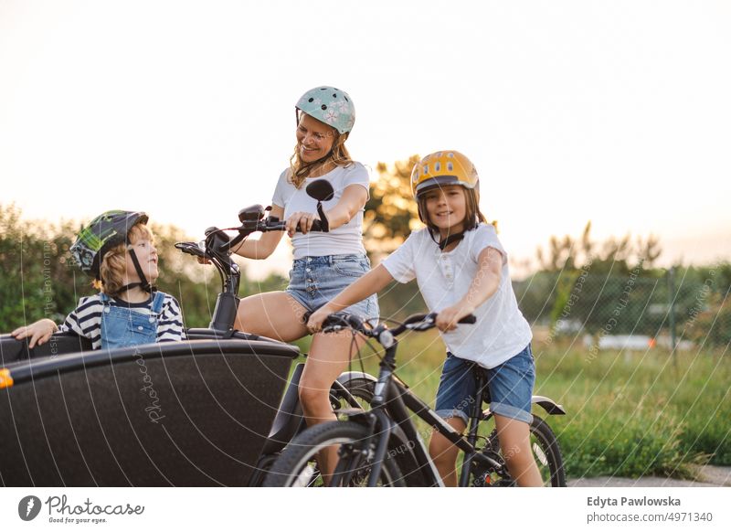 Mother with children cycling in the countryside day healthy lifestyle active lifestyle outdoors fun joy bicycle biking activity bike cyclist enjoying ecological