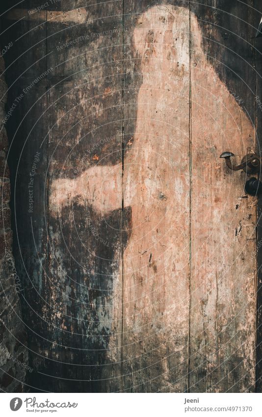 Mysterious figure on the old wooden door Figure Wooden door Old Mystic Mythology Shadow Closed Front door Door handle Historic Eerie Past Puzzle medieval