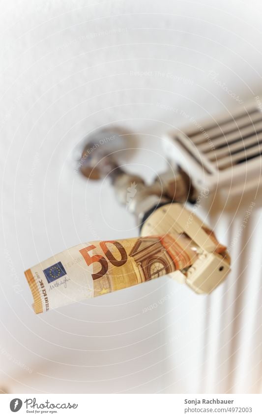 A fifty euro bill stuck in a thermostat on a radiator Fifty euro bill Money Heater Bank note heating costs Heating Energy Warmth Cold Winter Temperature White