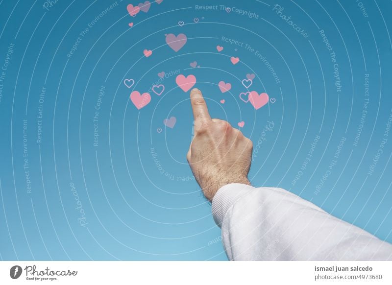 hand up in the air touching a heart shapes arm fingers skin palm body part clouds sky blue sky feeling reaching pointing hearts love love emotion valentine's