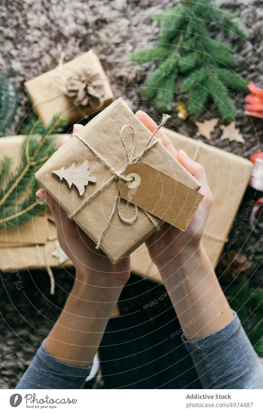 Closeup view of woman hands holding a handmade christmas present indoors surprise box leisure xmas wrapping celebration merry gift gold decoration decorated