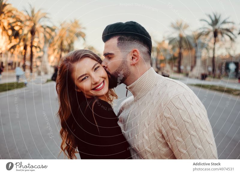 young attractive couple dating in the city kissing cheek urban walking barcelona holding hands man love woman spain black tourism vacation romantic beautiful