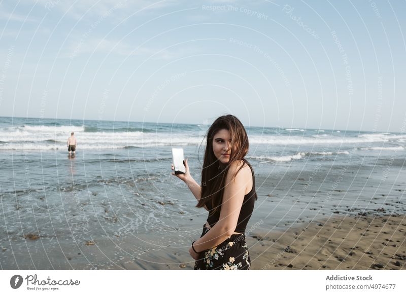 young woman taking pictures at beach phone nature mobile beautiful photo camera sea travel female holding summer person people smart girl smartphone sunny cell