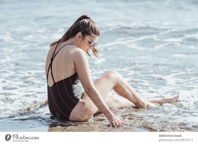 Thoughtful young woman in sunglasses sitting on the seashore beach ocean beauty summer relax hair girl nature beautiful pensive sunrise thinking thoughtful sand