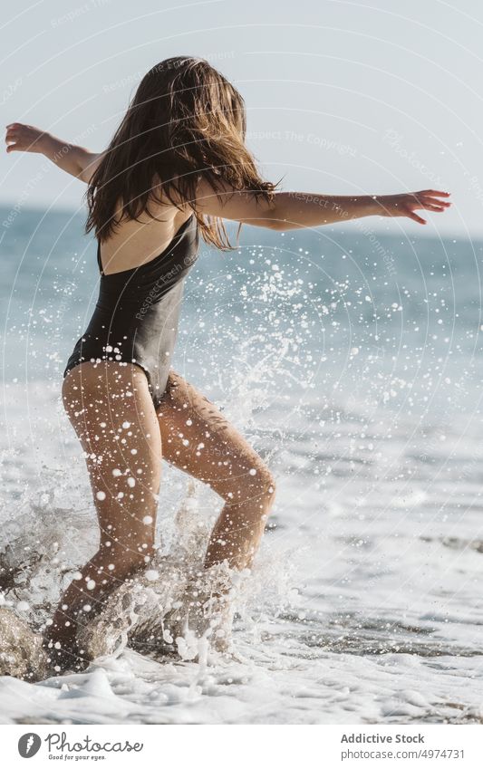 Woman playing with ocean waves on a sunny day woman sea person fun vacation outdoor summer joy young girl holiday nature water beach travel playful splashing