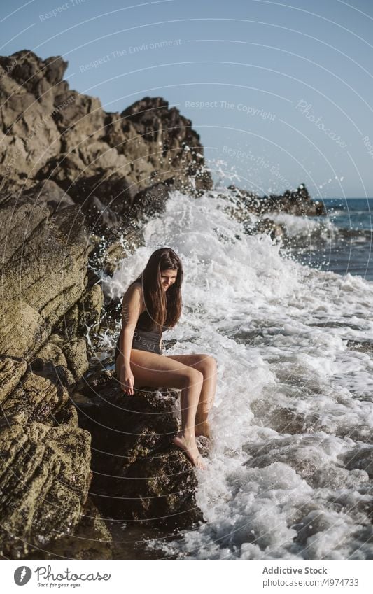 woman resting on rocky beach cliff beauty style nature coquette sea ocean pretty brunette long hair standing romantic trendy alluring summer vacation charming
