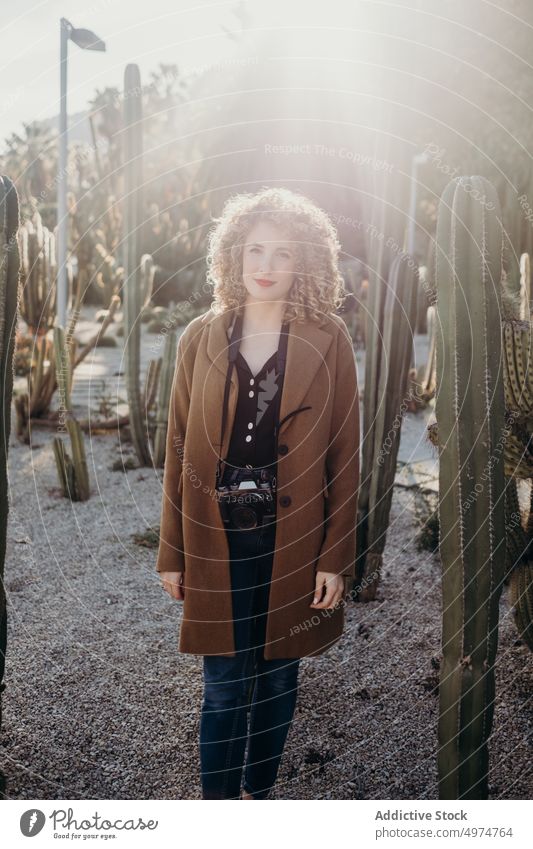 Portrait of beautiful curly blonde woman using a retro camera portrait model outdoors winter fashion face accessory apparel clothing coat confident cute elegant
