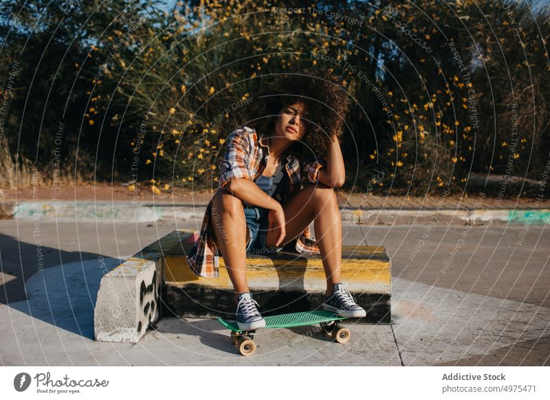 Tranquil African American woman with penny board on street summer skater cool millennial afro trendy tranquil hipster sunny female ethnic african american black