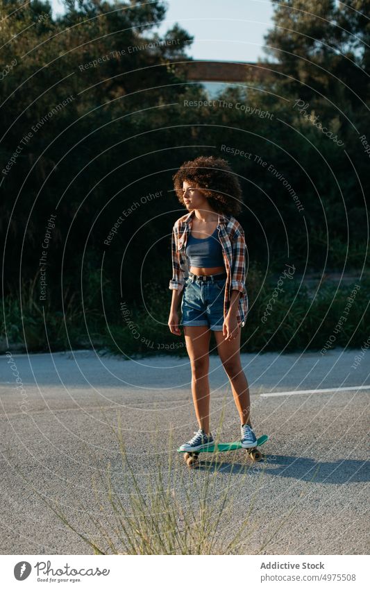Ethnic woman riding penny board ride sunset road summer hipster skater afro urban female ethnic street trendy tranquil entertain city chill evening sundown
