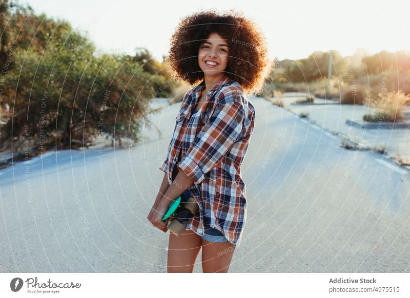 Cheerful ethnic woman with penny board road hipster summer skater afro sunset cheerful millennial female african american black trendy stand city chill urban