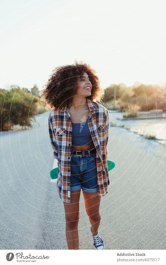 Cheerful ethnic woman with penny board road hipster summer skater afro sunset cheerful millennial female african american black trendy stand city chill urban