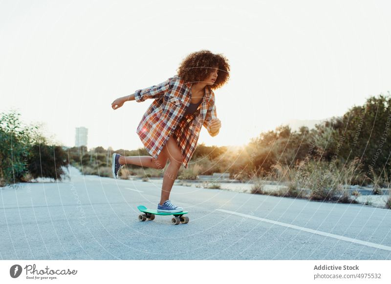 Ethnic woman riding penny board ride sunset road summer hipster skater afro urban female ethnic street trendy tranquil entertain city chill evening sundown