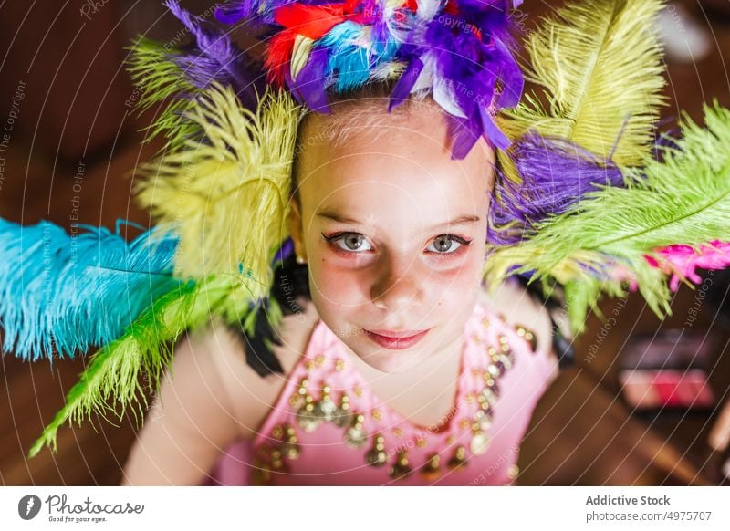 Little girl in carnival costume speak makeup headgear feather colorful kid child tradition glamour holiday fashion accessory style bright masquerade celebrate
