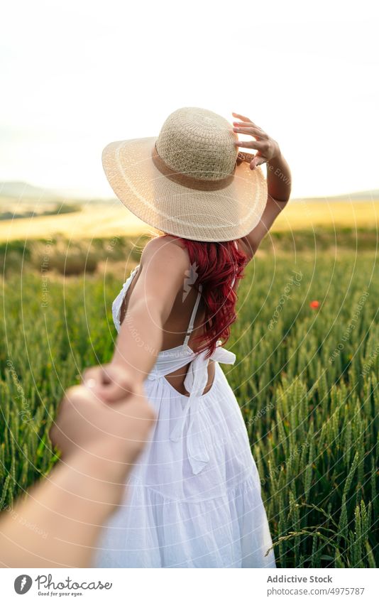 Anonymous woman holding crop beloved by hand in field follow me holding hands relationship romantic portrait feminine partner together interact spend time