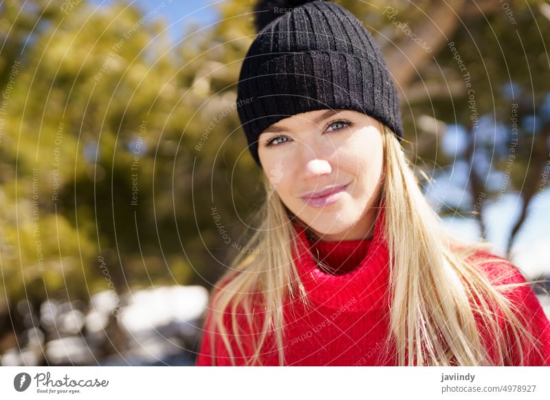 Young blonde woman in a snowy forest in the mountains in winter, in Sierra Nevada, Granada, Spain. nature sweater female girl leisure lifestyle outdoor portrait