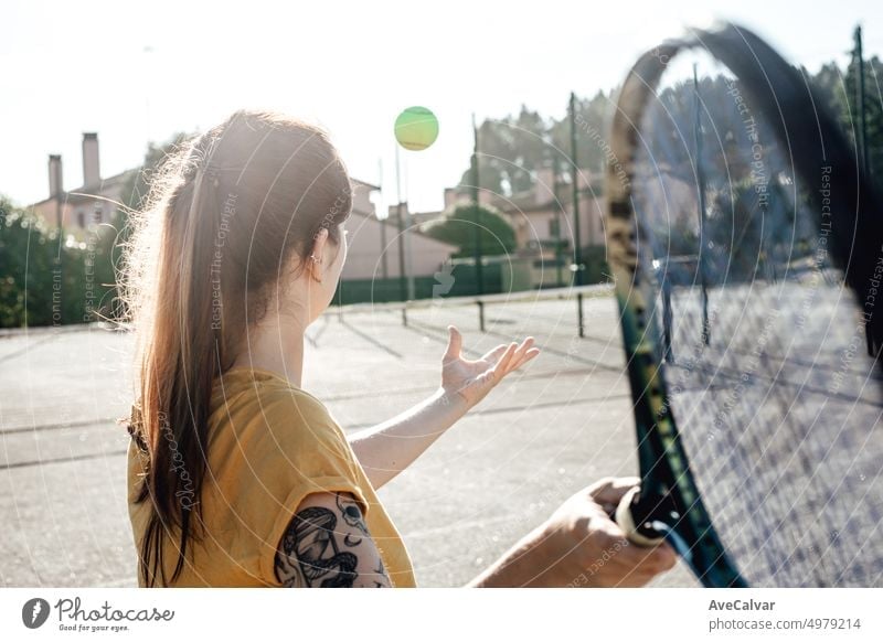 Young woman holding a racket ready to take a tennis serve showing students. Teaching new ways of exercise having fun. Coach motivates and trains to reach goals and aspirations. Healthy life and style