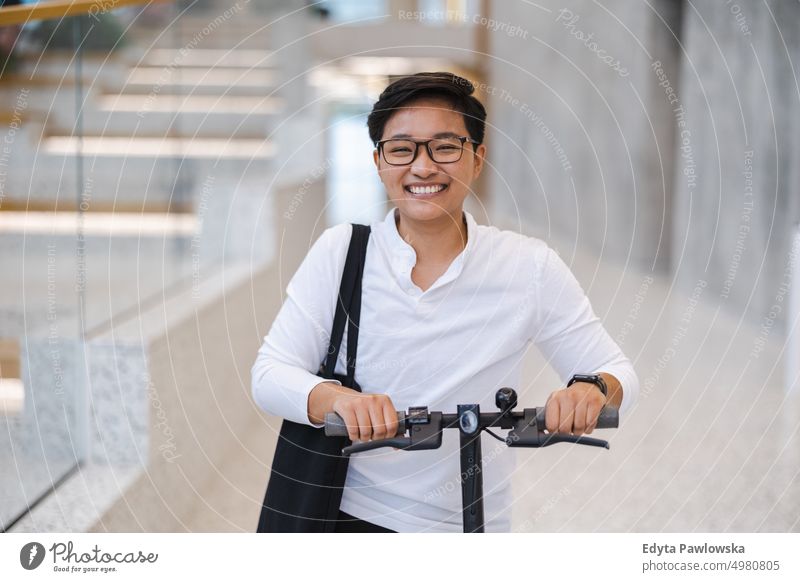 Young man with an electric scooter real people natural young adult city urban student positive smile cheerful career confident successful business person