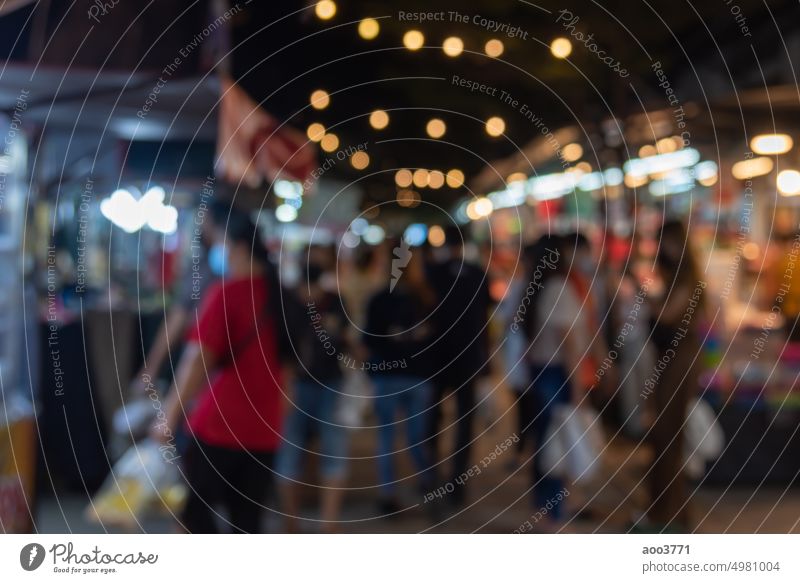 blurred image of night market festival people walking on road with light bokeh for background. person party crowd festive abstract blurry vintage shop business
