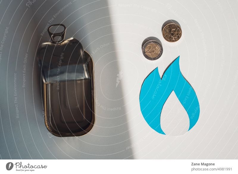 Natural gas symbol with coins and an empty tin can, choosing between heating bills and groceries natural gas gas consumption gas money saving natural resources