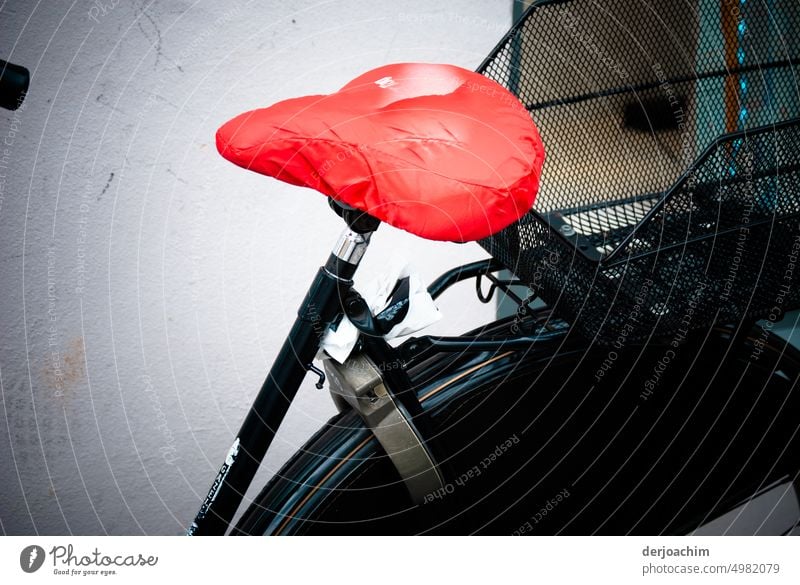 My black bike saddle has a red protective cover. Bicycle Contrast Summer protective tarpaulin stands Red Wall & Wall Deserted Colour photo Means of transport
