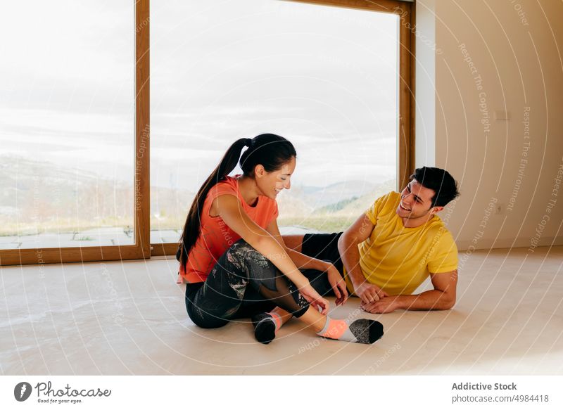 Slim lady and guy sitting resting in room cheerful sport sportswear woman athletic slim active window activity gymnastic panorama mountain view countryside