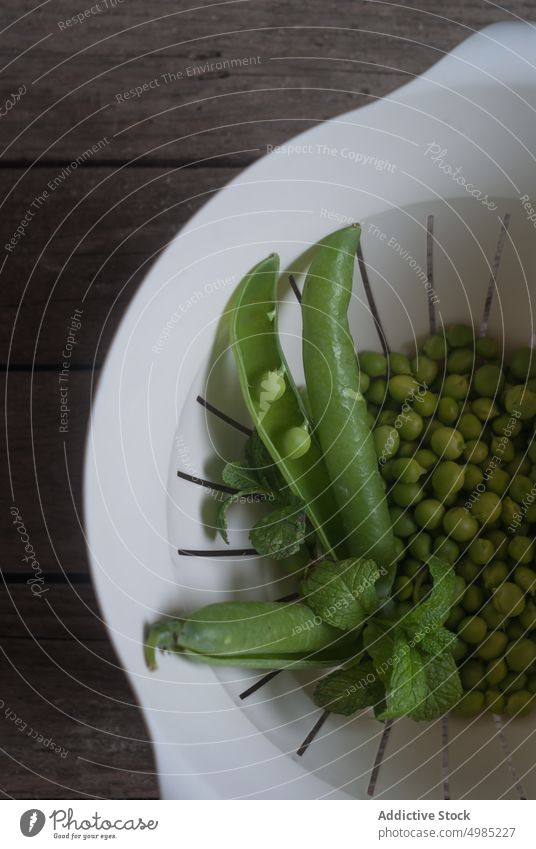 Drain bowl with peas and mint pods fresh green leaves rustic agriculture growth plant ripe organic snack seed health vegetarian raw harvest clean wash small