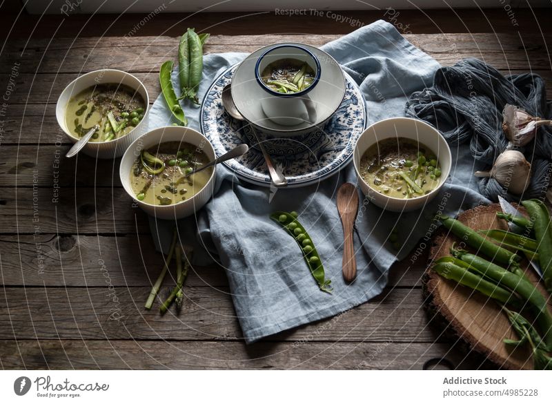 Composition of soup bowls and pea pods composition rustic green gourmet natural cooking eating vegetable served view vegan organic coconut cream design layout