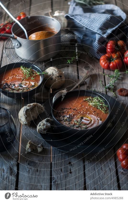 Creamy tomato soup with dried apricots cream served seeds organic buns delicious vegan garnish bread gourmet dish dinner fresh food bowl nutrition vitamin
