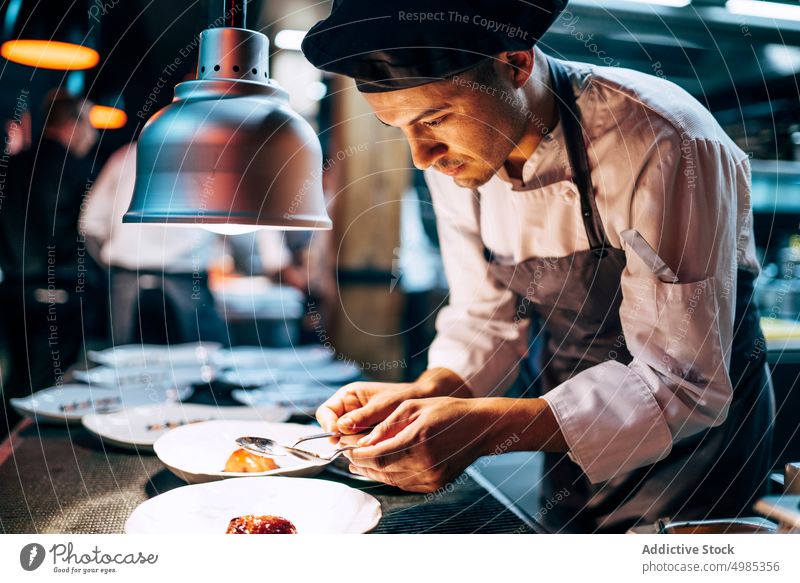 Professional chef serving food on plates serve sauce pour meal dishes garnish gastronomy restaurant commercial gourmet culinary interior cuisine table kitchen