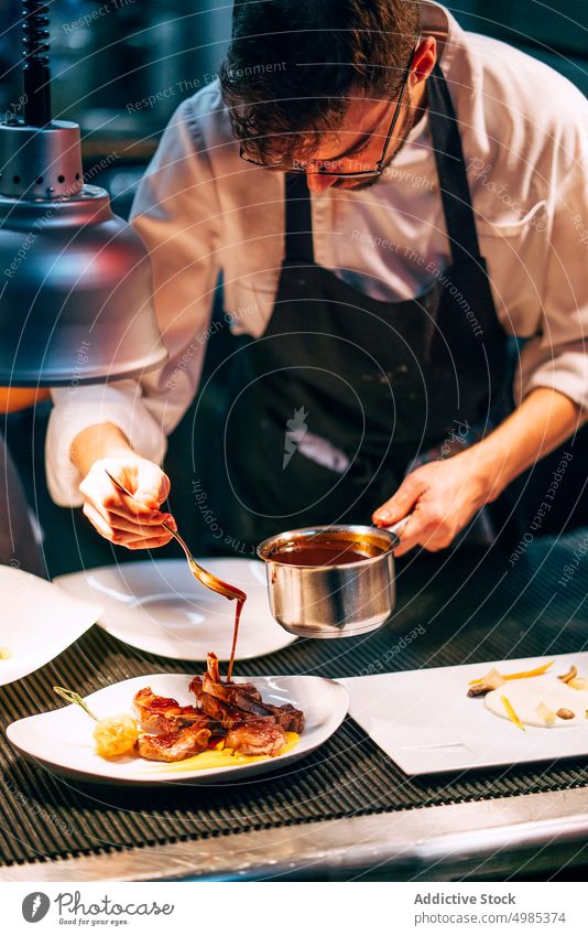 Professional chef pouring sauce on served meat dinner recipe fresh restaurant delicacy plate gastronomy dish delicious meal food contemporary cookware