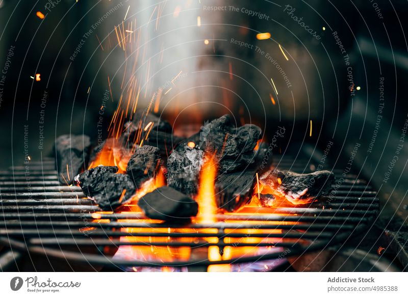 Burning coal on grill blaze sparkle fire bbq light cooking prepare production combustion hot charcoal temperature bright flame energy flammable flare smoke