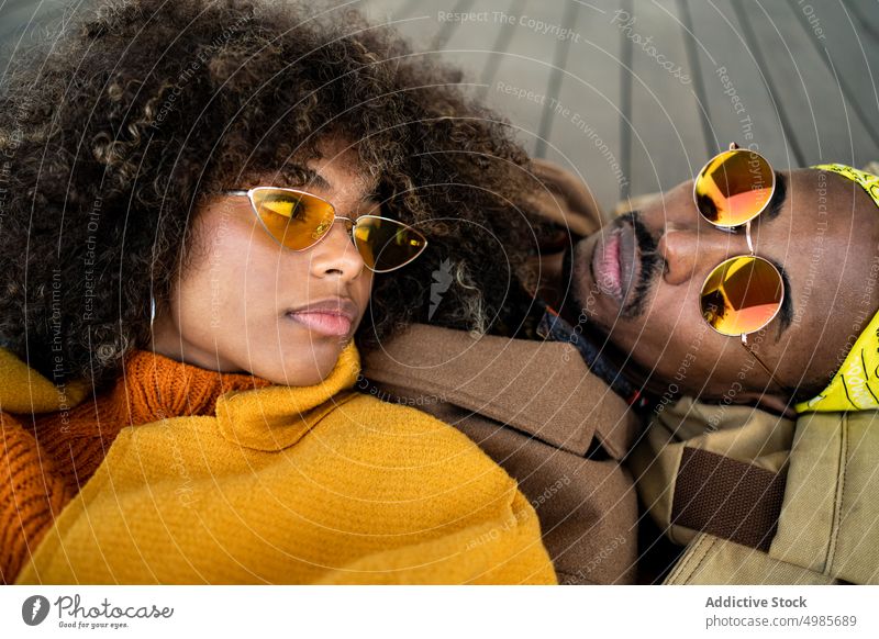 Sensual black couple in colorful clothes lying on the floor love trendy lying down fashion together autumn ethnic african american tender romantic style fall