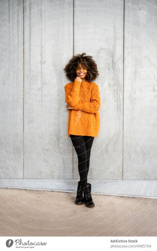 Trendy black woman in bright sweater on street colorful street style cheerful ethnic african american modern cool slim sunglasses charming hairstyle afro model