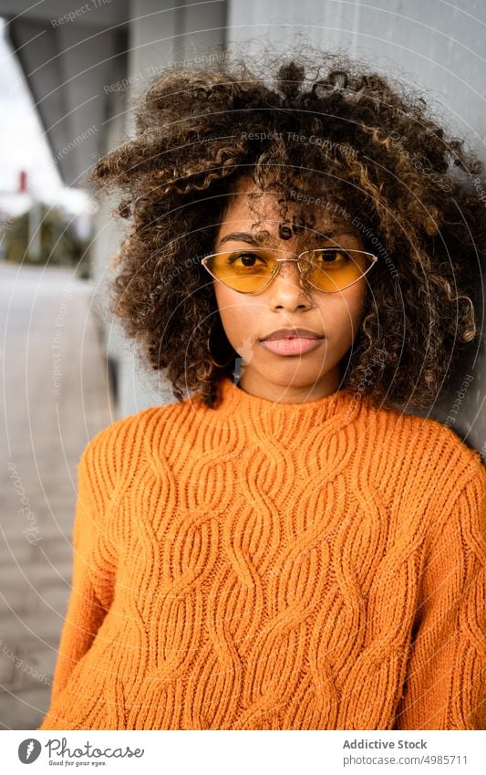 Trendy black woman in bright sweater on street colorful street style ethnic african american modern cool slim sunglasses charming hairstyle afro model trendy