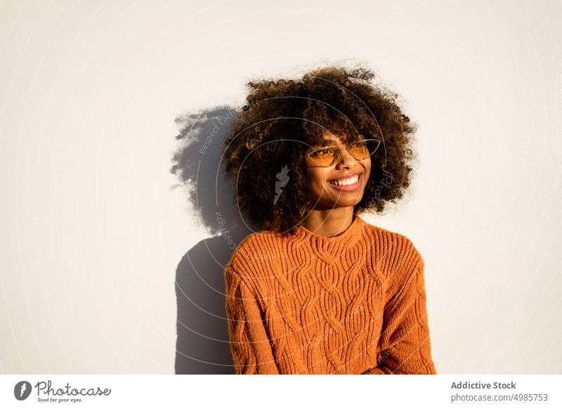Trendy black woman in bright sweater on street colorful street style cheerful ethnic african american modern cool slim sunglasses charming hairstyle afro model