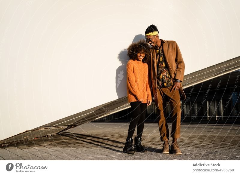 Modern black man and woman against white wall in sunset couple style city ethnic together street style cool african american contemporary sunlight sunglasses