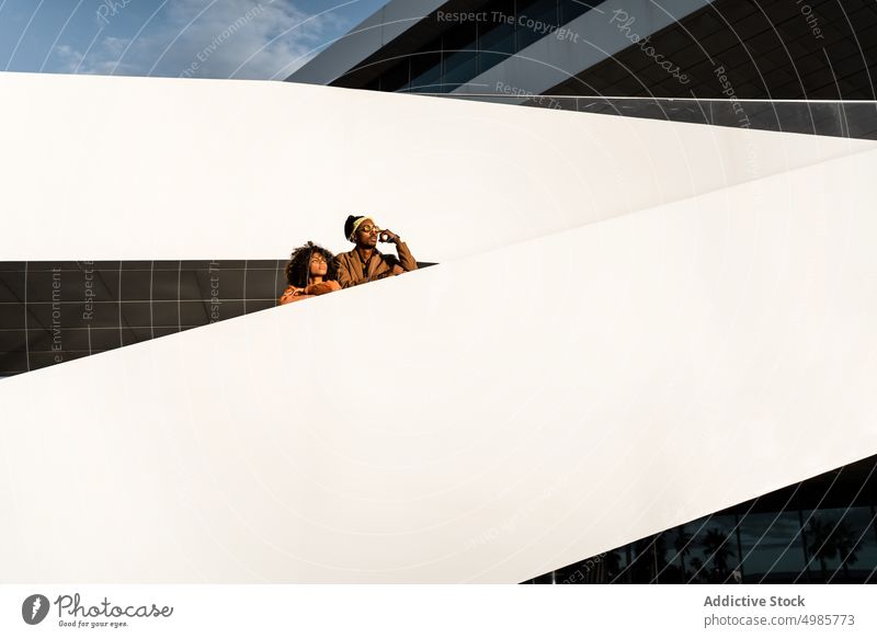 Dreaming trendy couple on stairs watching sunset in city street style architecture dream urban modern ethnic black african american sky sunlight together