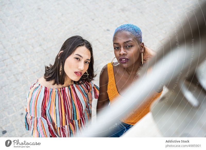 Stylish multiethnic couple of women in city lesbian girlfriend lgbt peep out together homosexual relationship multiracial diverse black african american asian
