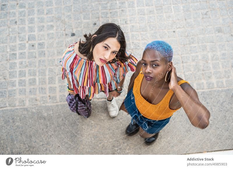 Stylish multiethnic couple of lesbian women in city cool urban style lgbt same sex girlfriend street multiracial diverse black african american asian together