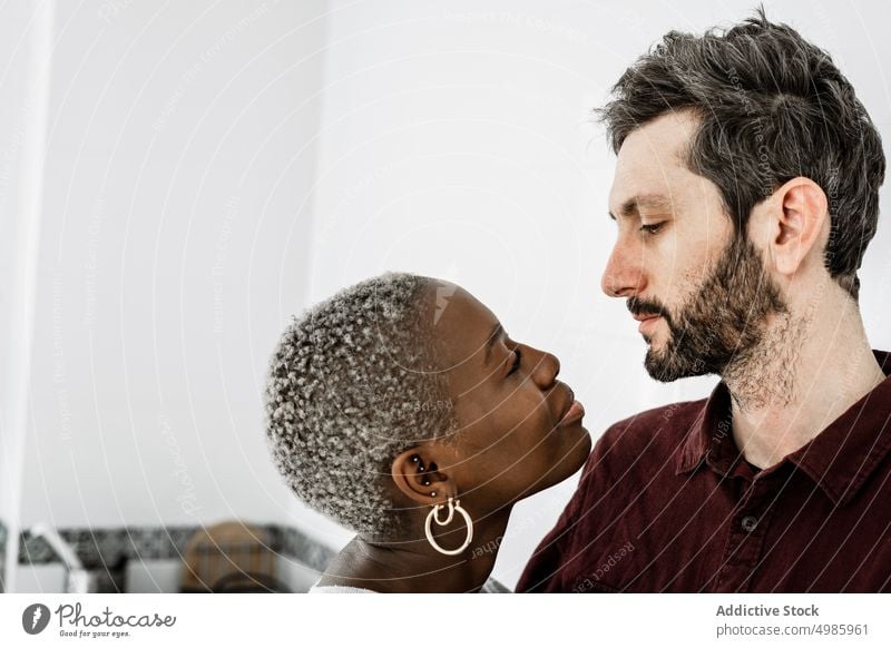 Tender multiethnic couple at home love embrace cuddle relationship casual smile together romantic affection african american apartment black diverse tender