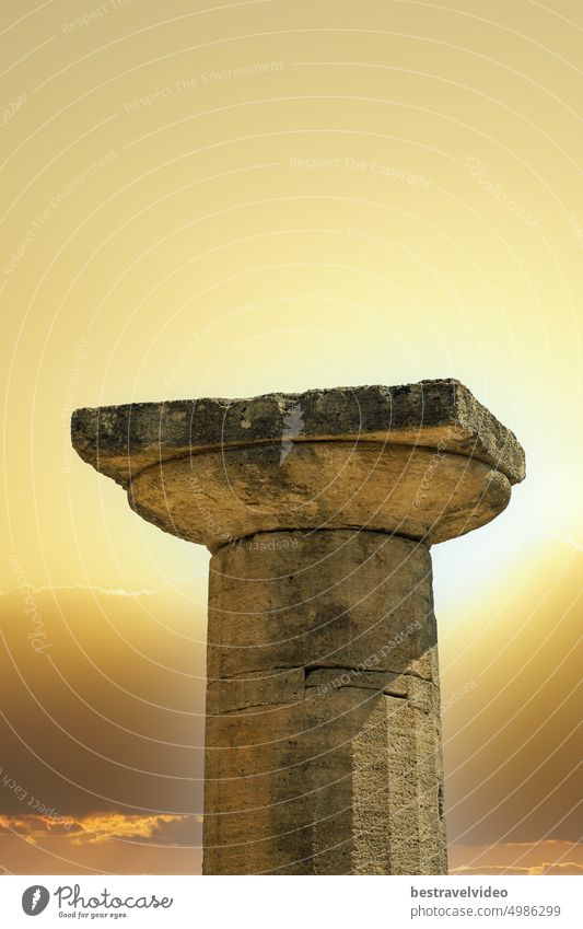 Ancient classical architecture Doric Greek column against a bright sun. Ancient Greek column grooved shaft round flare on top antiquity archaeology sunny view